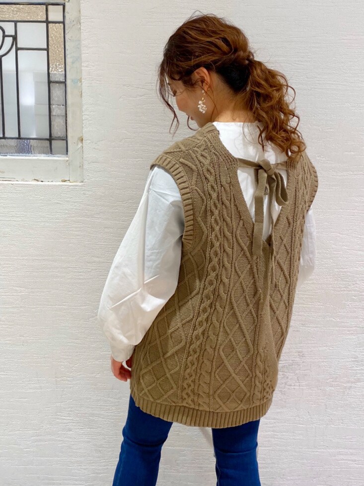 ブルー系のデニムパンツ、ホワイト系のパンプス、シルバー系のショルダーバッグを着用したレディースの春コーディネートの4枚目の写真