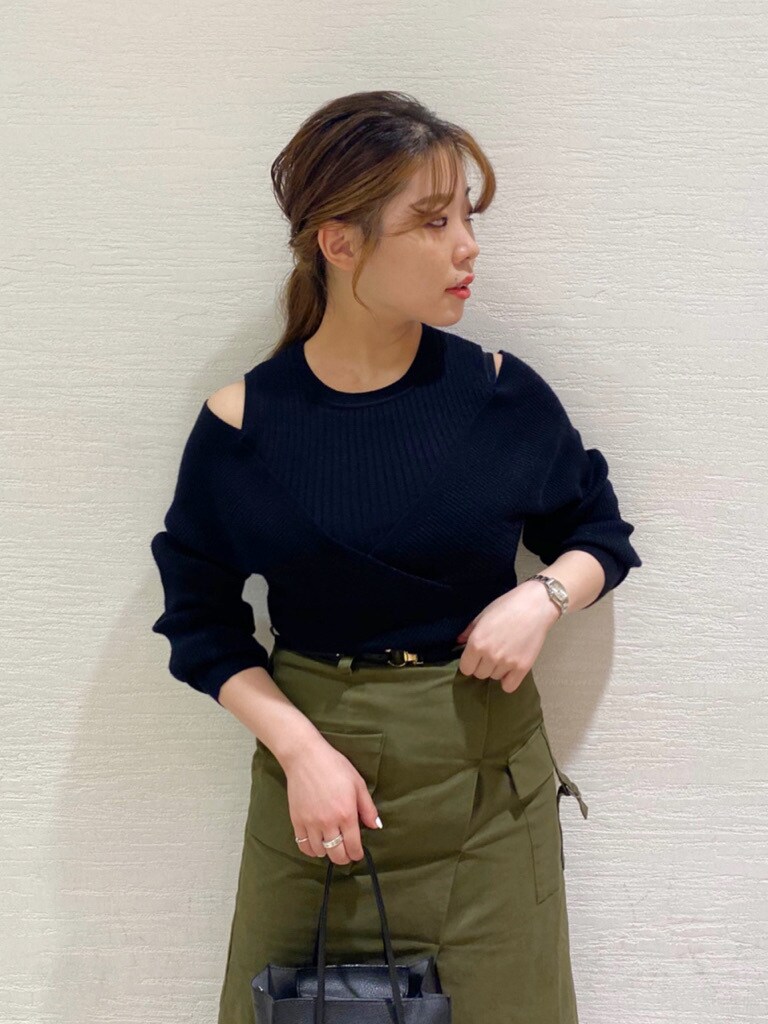 ベージュ系のパンプス、ブラック系のニット/セーター、グリーン系のスカートを着用したレディースの夏コーディネートの3枚目の写真