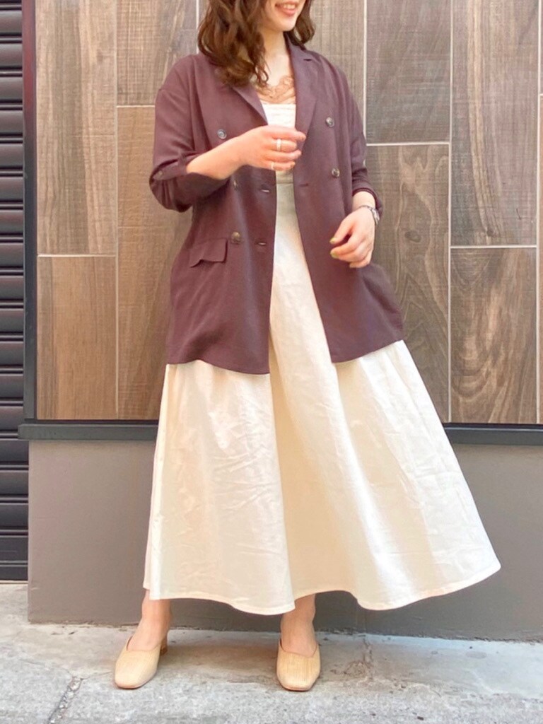 ブラウン系のテーラードジャケット、ホワイト系のワンピース、ホワイト系のパンプスを着用したレディースの春コーディネートの3枚目の写真