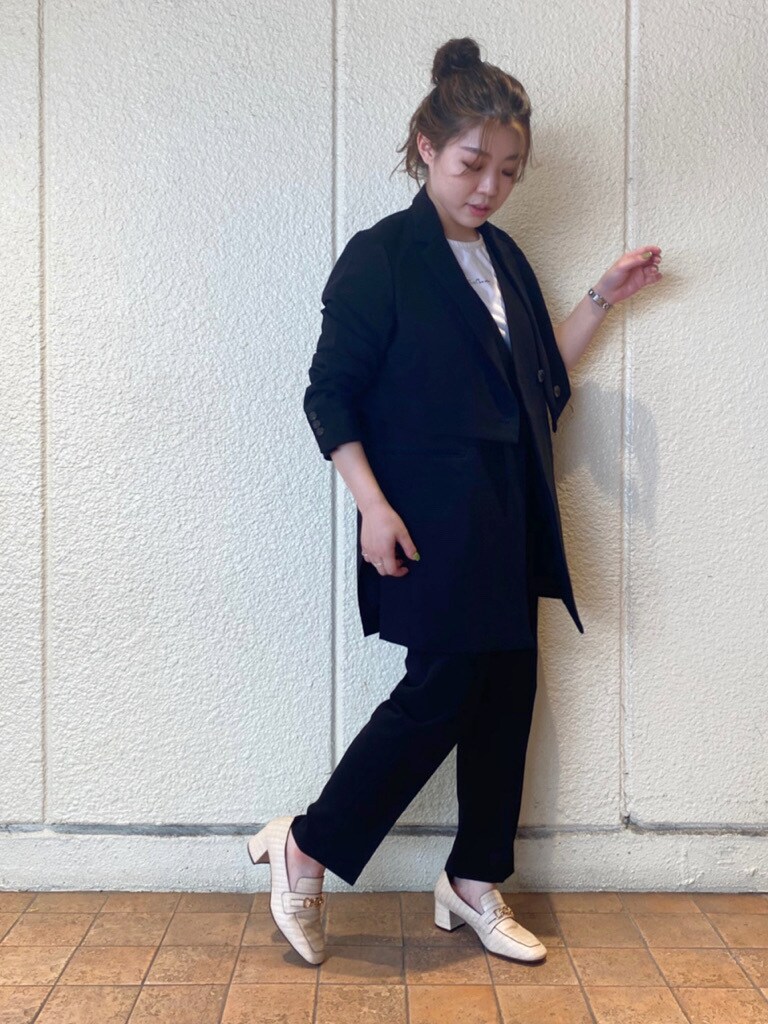 ブラック系のテーラードジャケット、ブラック系のベスト、ホワイト系のローファーを着用したレディースの夏コーディネートの3枚目の写真