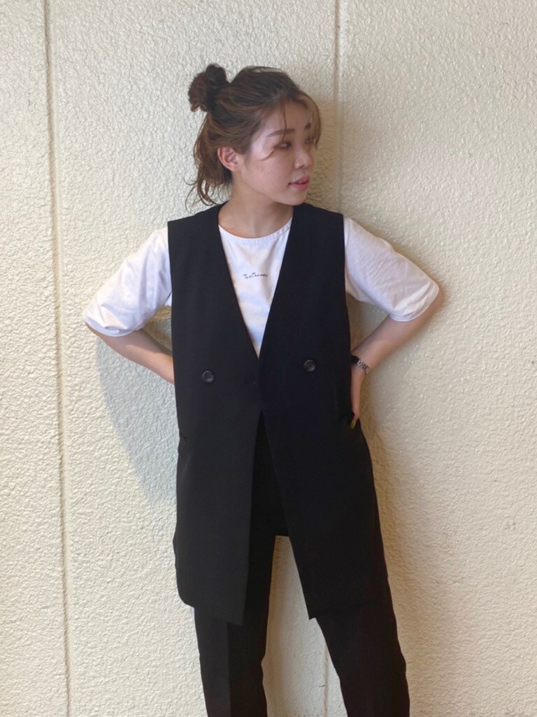 ブラック系のテーラードジャケット、ブラック系のベスト、ホワイト系のローファーを着用したレディースの夏コーディネートの6枚目の写真