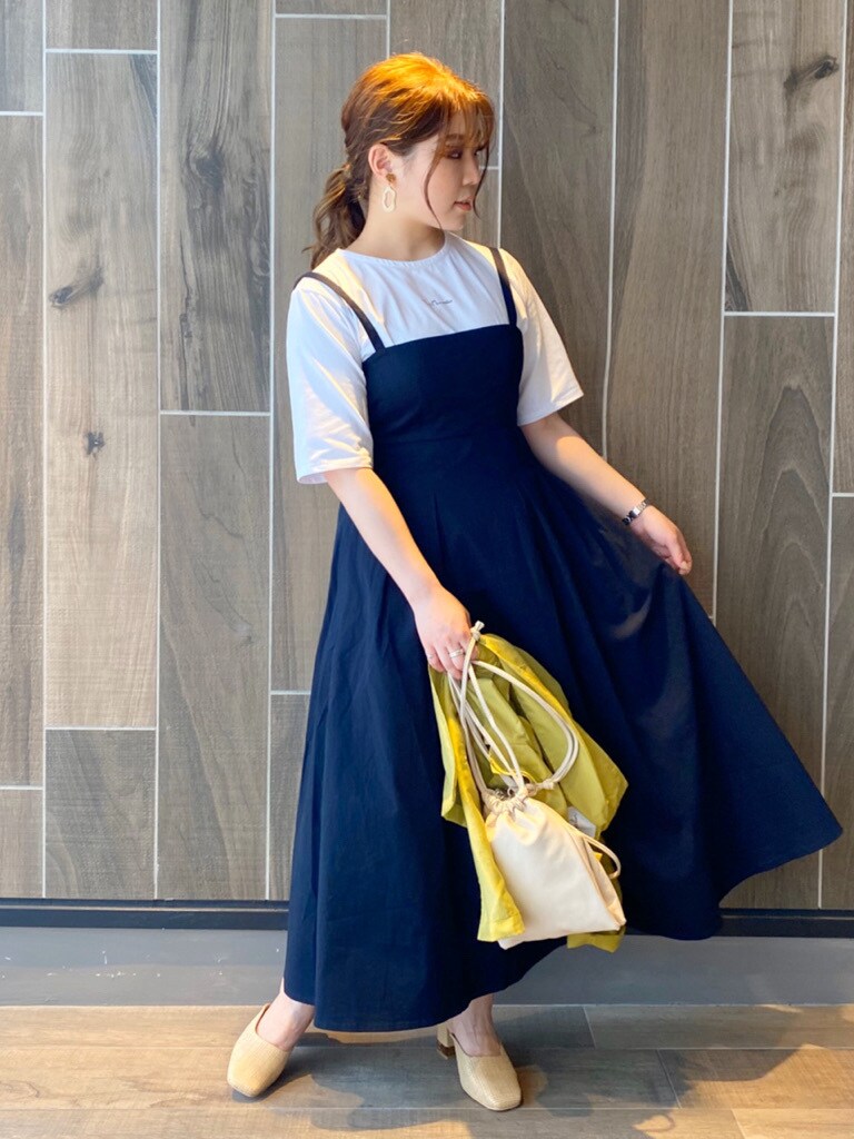 ホワイト系のパンプス、ホワイト系のハンドバッグ、ホワイト系のTシャツ/カットソーを着用したレディースの夏コーディネートの2枚目の写真