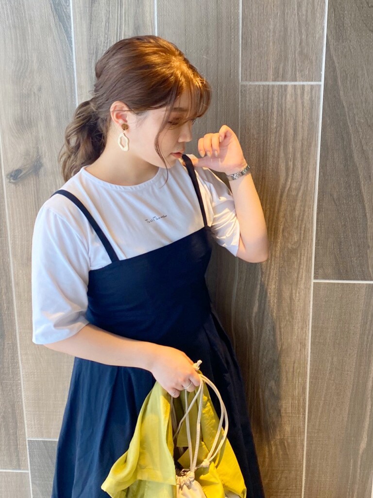 ホワイト系のパンプス、ホワイト系のハンドバッグ、ホワイト系のTシャツ/カットソーを着用したレディースの夏コーディネートの3枚目の写真