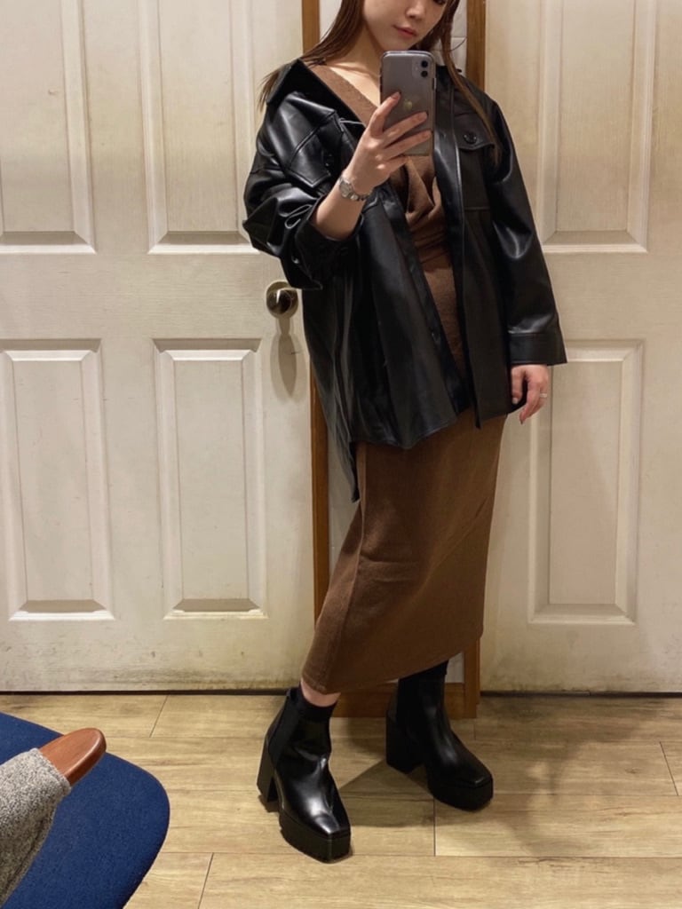 ブラック系のテーラードジャケット、ブラウン系のワンピース、ブラック系のブーツを着用したレディースの秋コーディネートの2枚目の写真