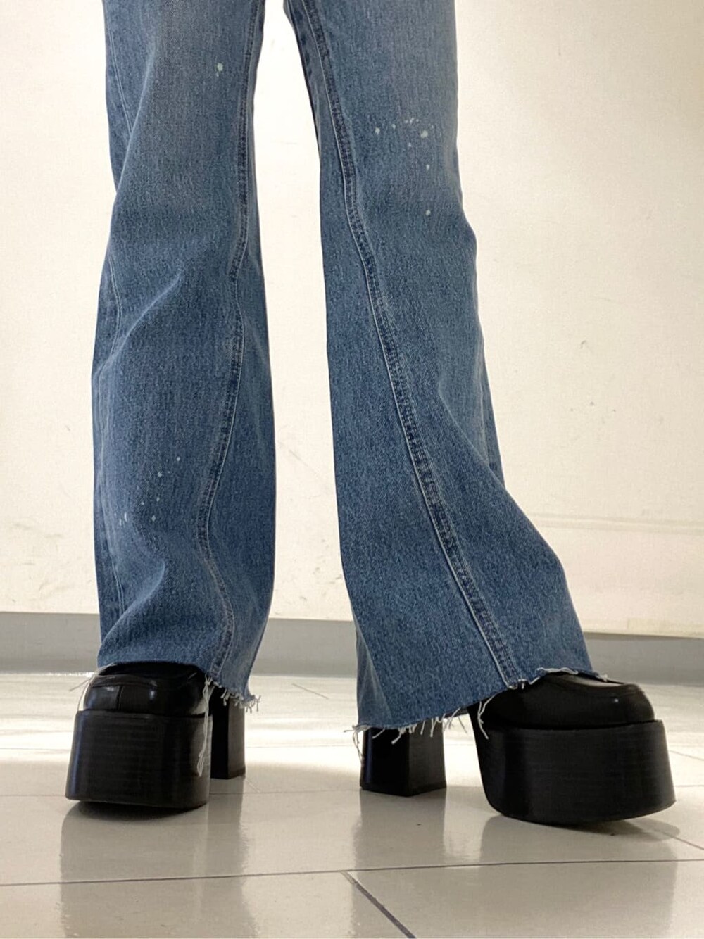 ブラック系のニット/セーター、ブルー系のデニムパンツ、ブラック系のローファーを着用したレディースの冬コーディネートの5枚目の写真