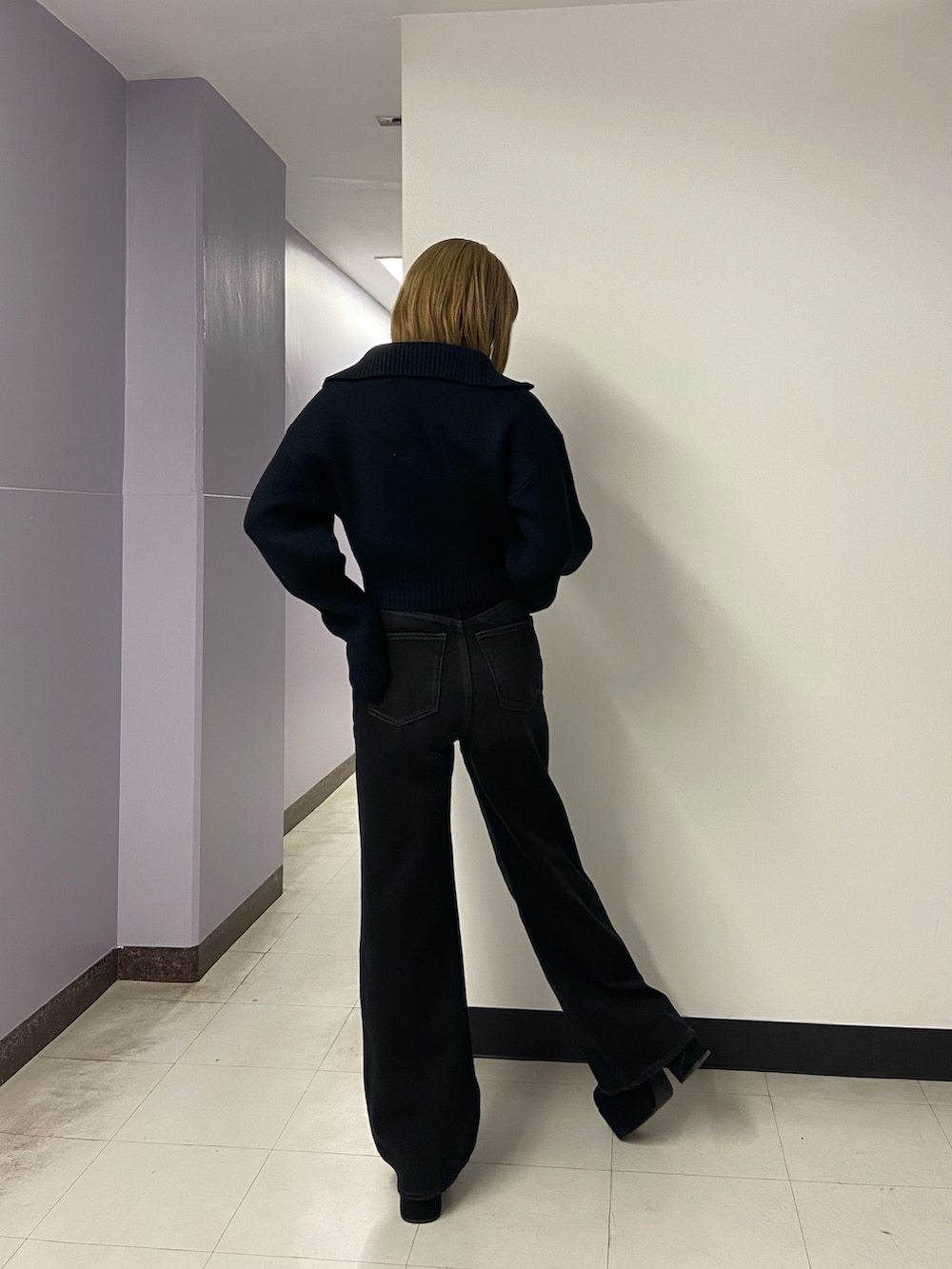 ブラック系のデニムパンツ、ブラック系のブーツ、ブラック系のニット/セーターを着用したレディースの秋コーディネートの4枚目の写真