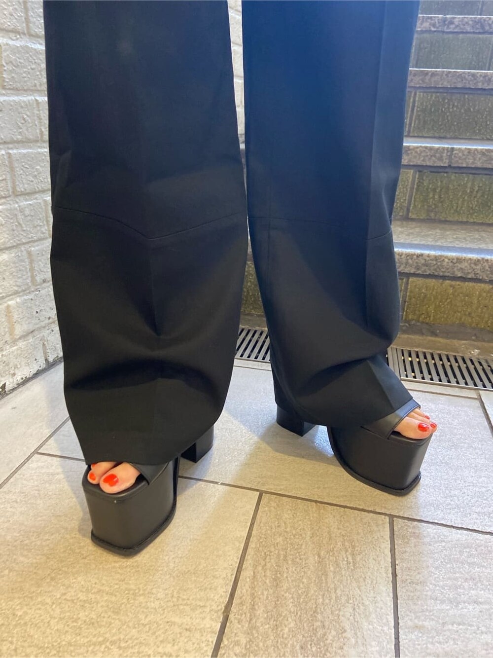 ブラック系のサンダル、ブラック系のその他パンツ、ホワイト系のTシャツ/カットソーを着用したレディースの夏コーディネートの7枚目の写真