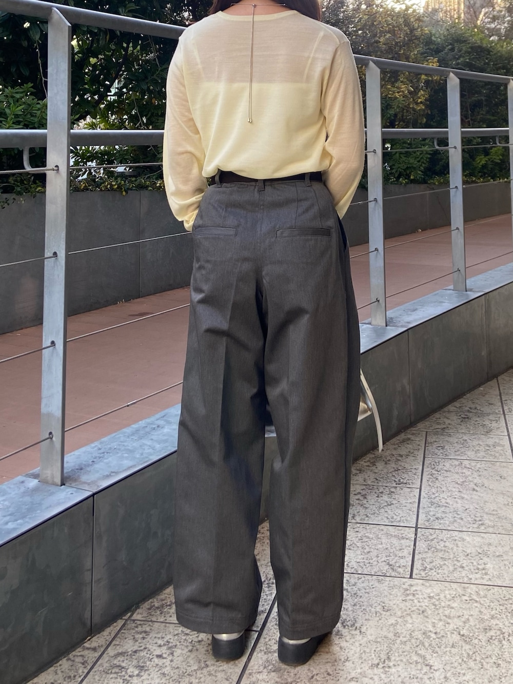 イエロー系のニット/セーター、グレー系のその他パンツ、シルバー系のローファーを着用したレディースの冬コーディネートの3枚目の写真