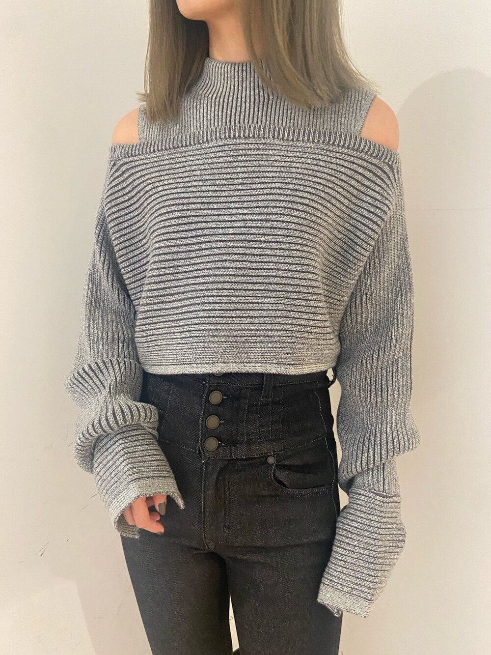 グレー系のニット/セーター、ブラック系のデニムパンツ、ブラック系のブーツを着用したレディースの秋コーディネートの4枚目の写真