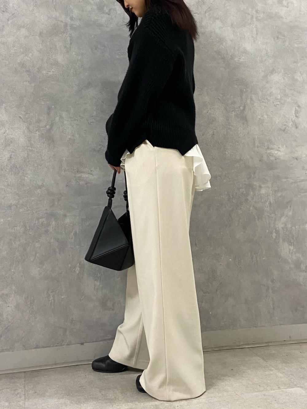 ブラック系のニット/セーター、ホワイト系のその他パンツ、ブラック系のブーツを着用したレディースの冬コーディネートの2枚目の写真