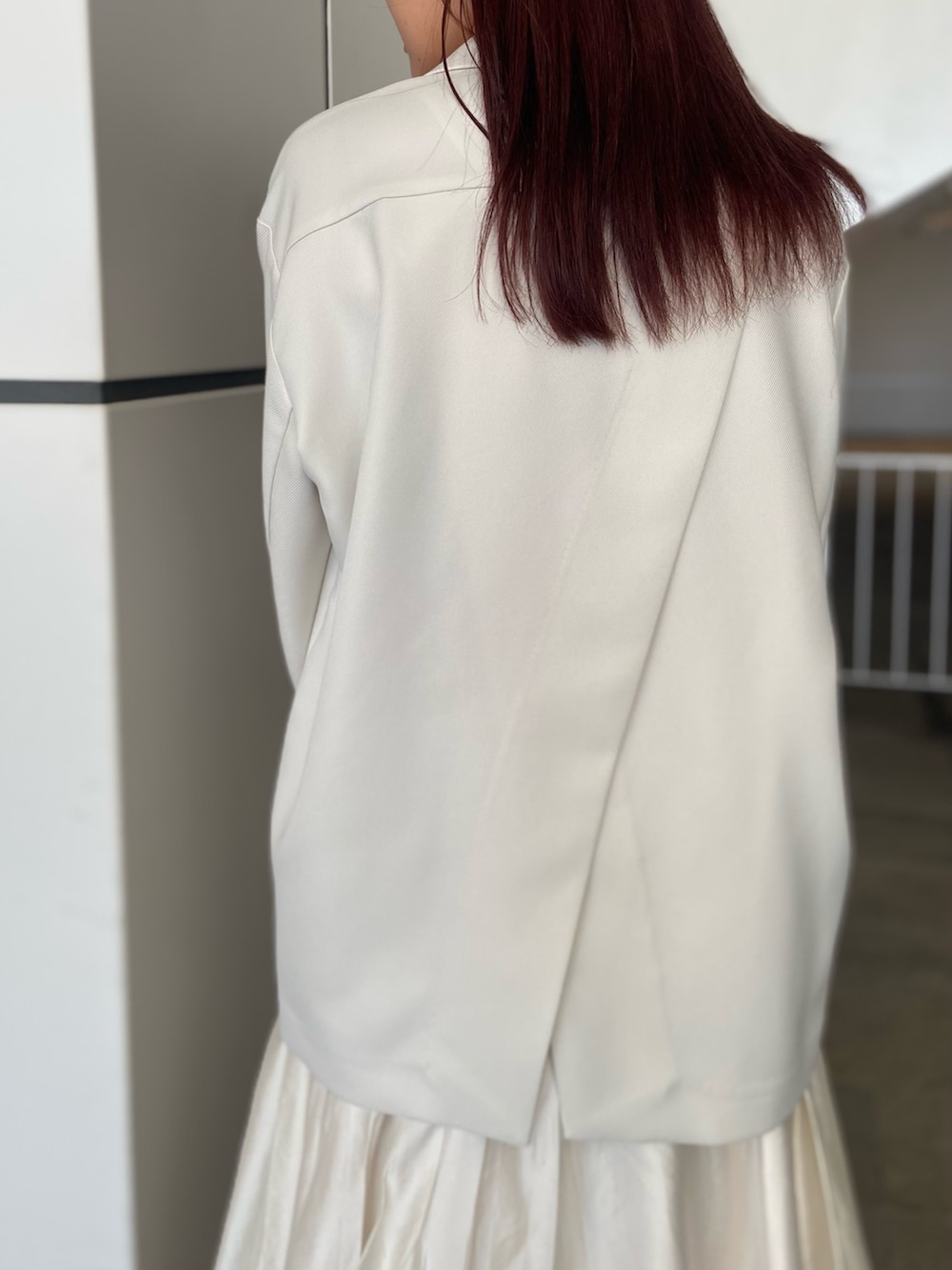 ホワイト系のテーラードジャケット、ホワイト系のスカート、ゴールド系のサンダルを着用したレディースの冬コーディネートの5枚目の写真