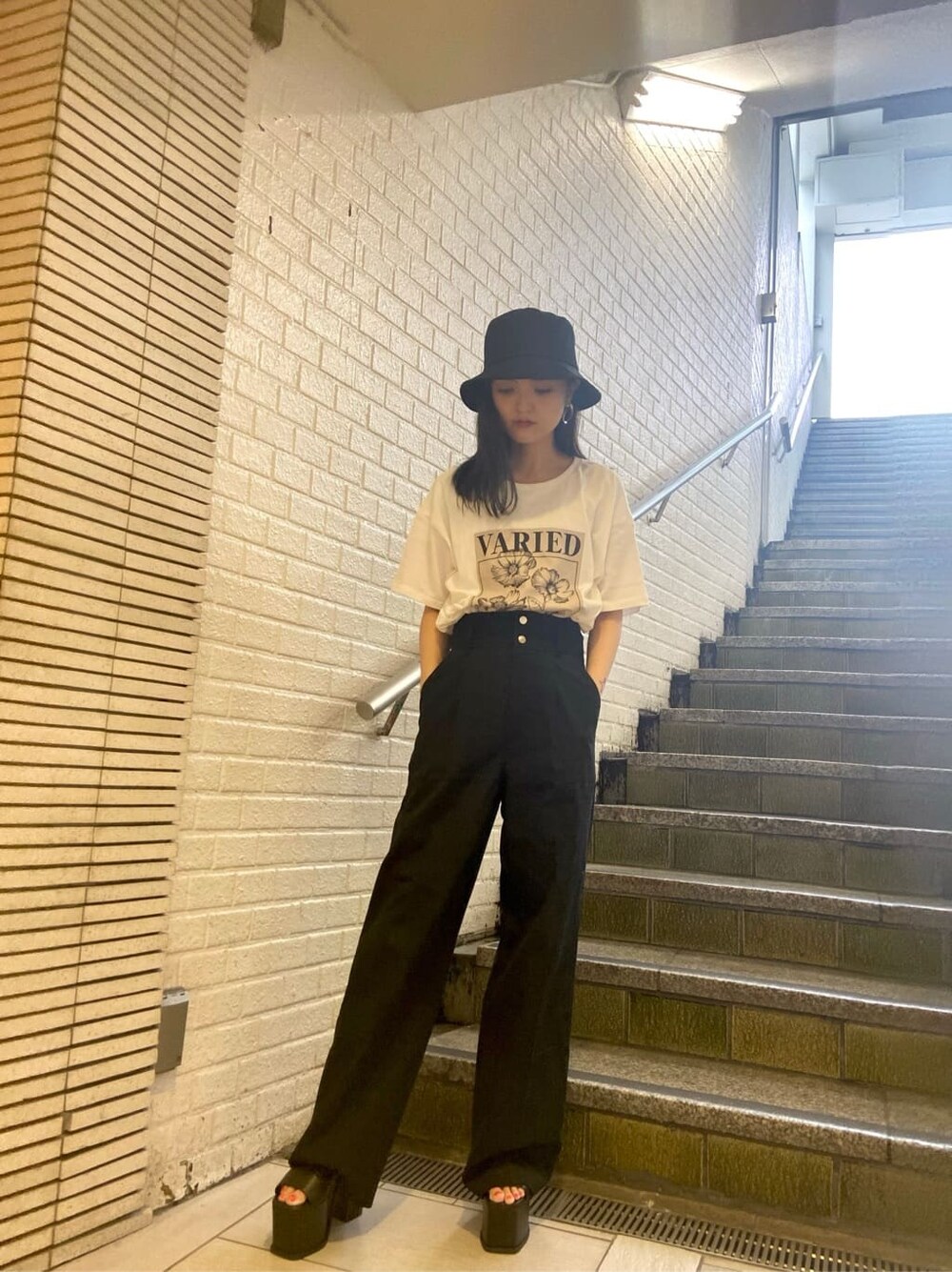 ブラック系のサンダル、ブラック系のその他パンツ、ホワイト系のTシャツ/カットソーを着用したレディースの夏コーディネートの2枚目の写真