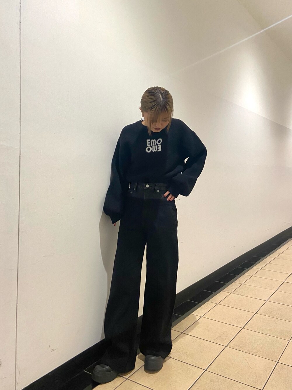 ブラック系のブーツ、ブルー系のニット/セーター、ブラック系のデニムパンツを着用したレディースの冬コーディネートの2枚目の写真