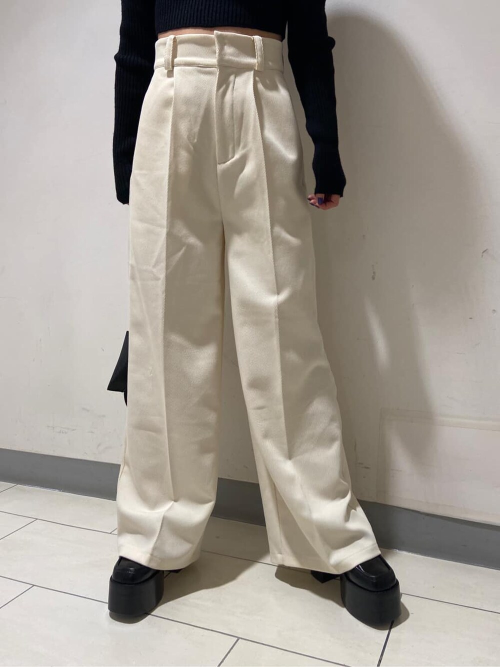 ホワイト系のその他パンツ、ブラック系のローファー、ブラック系のハンドバッグを着用したレディースの冬コーディネートの4枚目の写真