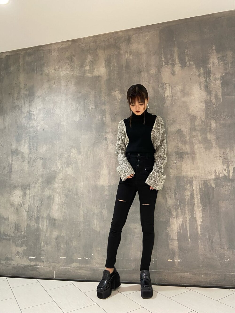 ブラック系のローファー、ブラック系のニット/セーター、ブラック系のデニムパンツを着用したレディースの秋コーディネートの7枚目の写真