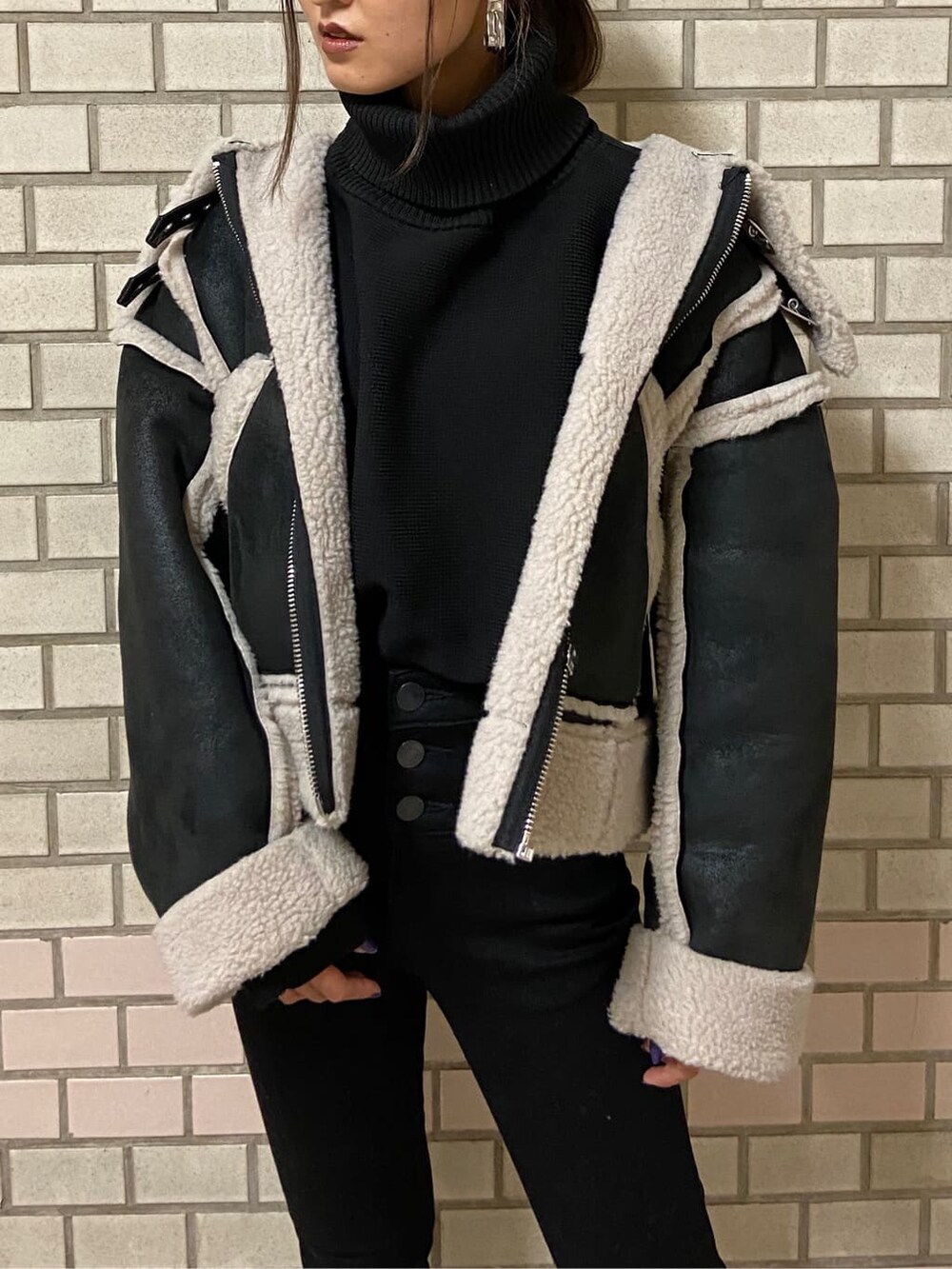 その他のムートンコート、ブラック系のブーツ、ブラック系のニット/セーターを着用したレディースの秋コーディネートの2枚目の写真