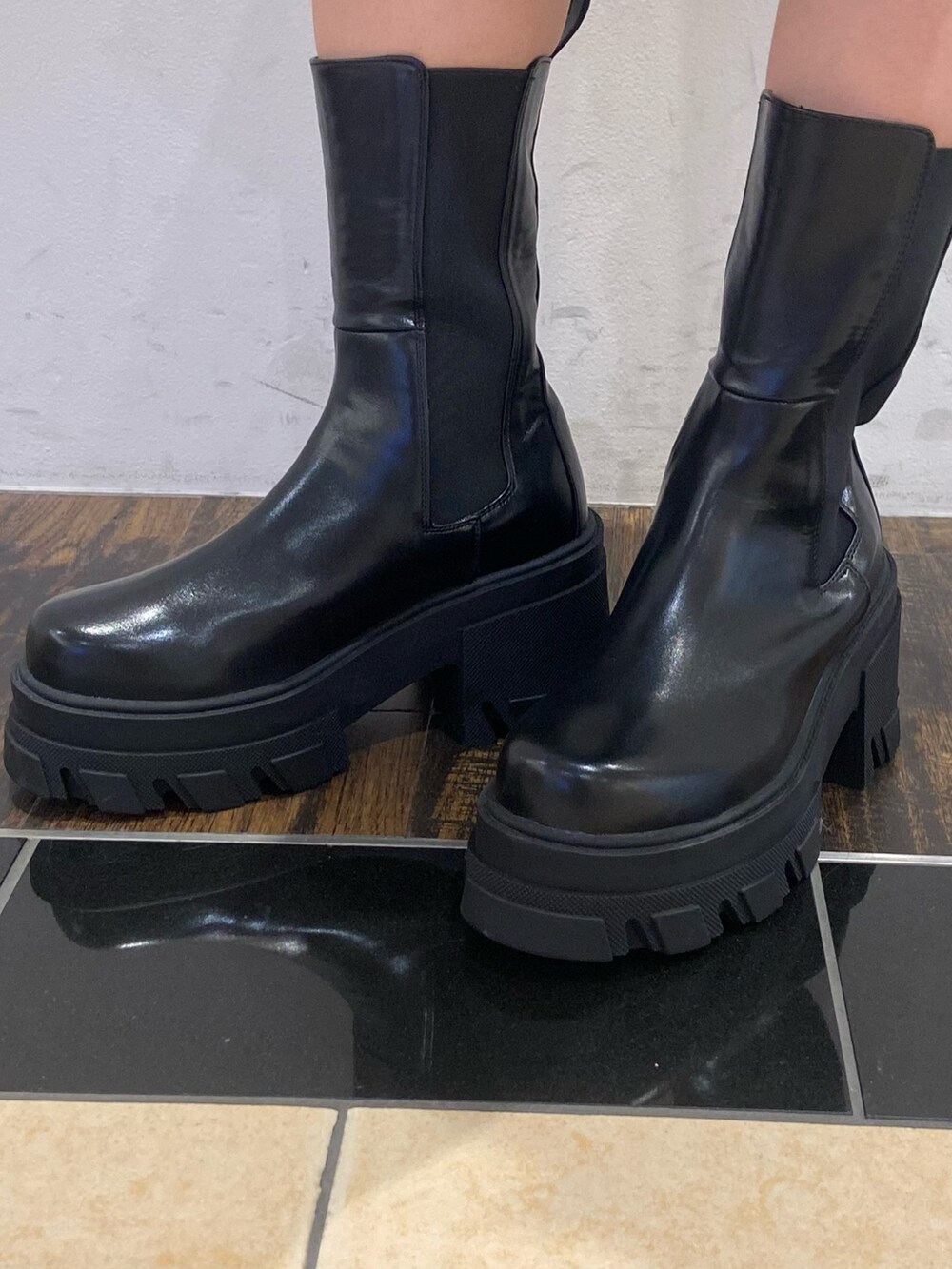 ブラック系のタンクトップ、ブラック系のデニムパンツ、ブラック系のブーツを着用したレディースの夏コーディネートの6枚目の写真