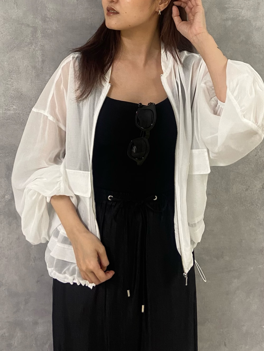 ホワイト系のブルゾン、ブラック系のタンクトップ、ブラック系のスカートを着用したレディースの春コーディネートの4枚目の写真