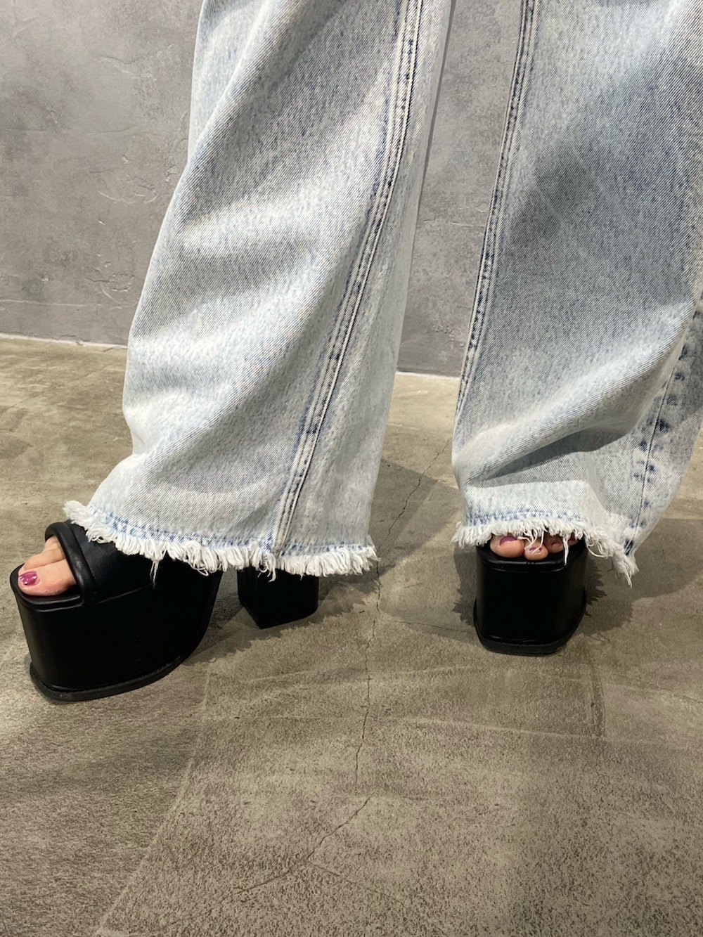 ブルー系のデニムパンツ、ブラック系のサンダルを着用したレディースの春コーディネートの7枚目の写真