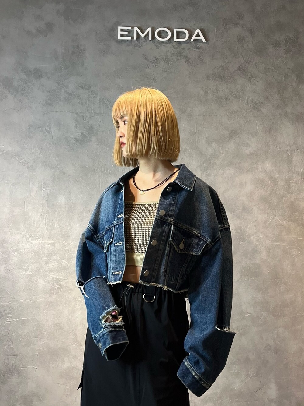 ブルー系のデニムジャケット、ベージュ系のキャミソール、ブラック系のスカートを着用したレディースの春コーディネートの4枚目の写真