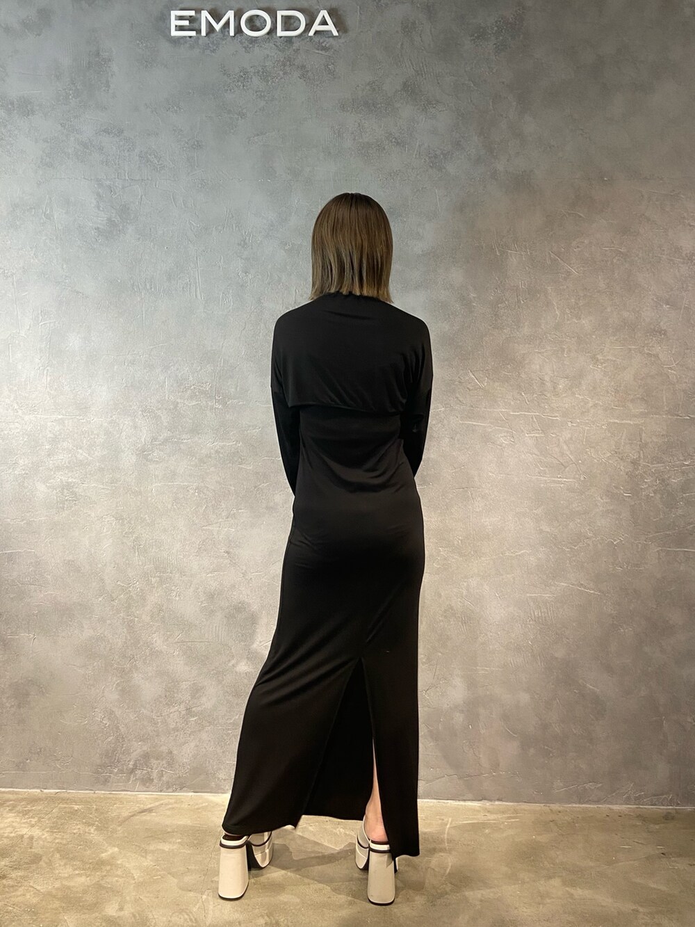 ブラック系のワンピース、ブラック系のハンドバッグ、ホワイト系のサンダルを着用したレディースの春コーディネートの5枚目の写真