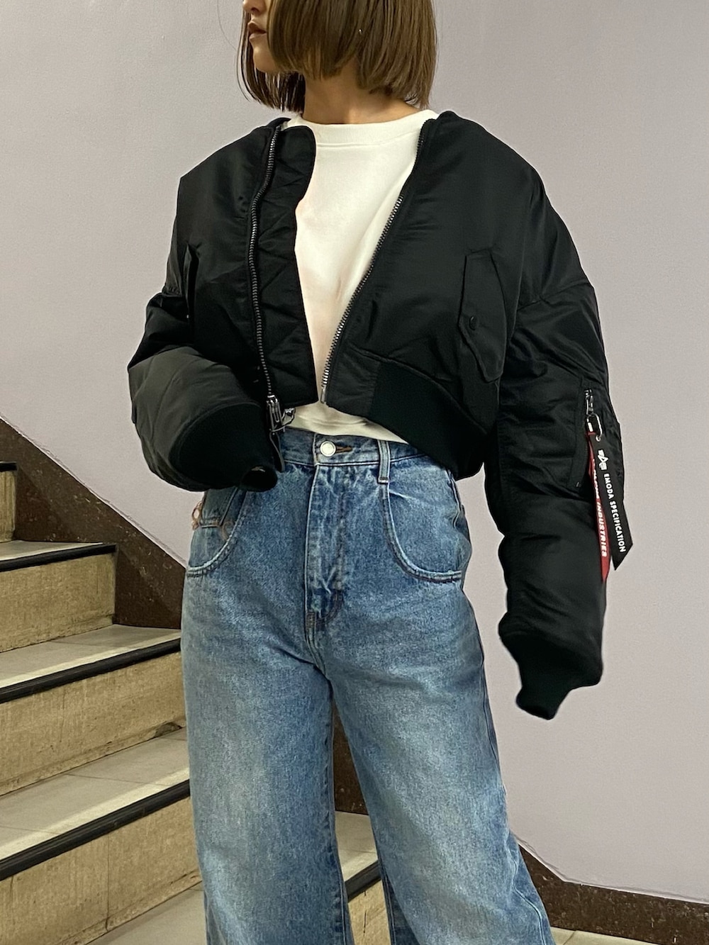 ブルー系のデニムパンツ、ブラック系のブーツ、ホワイト系のスウェットを着用したレディースの秋コーディネートの5枚目の写真