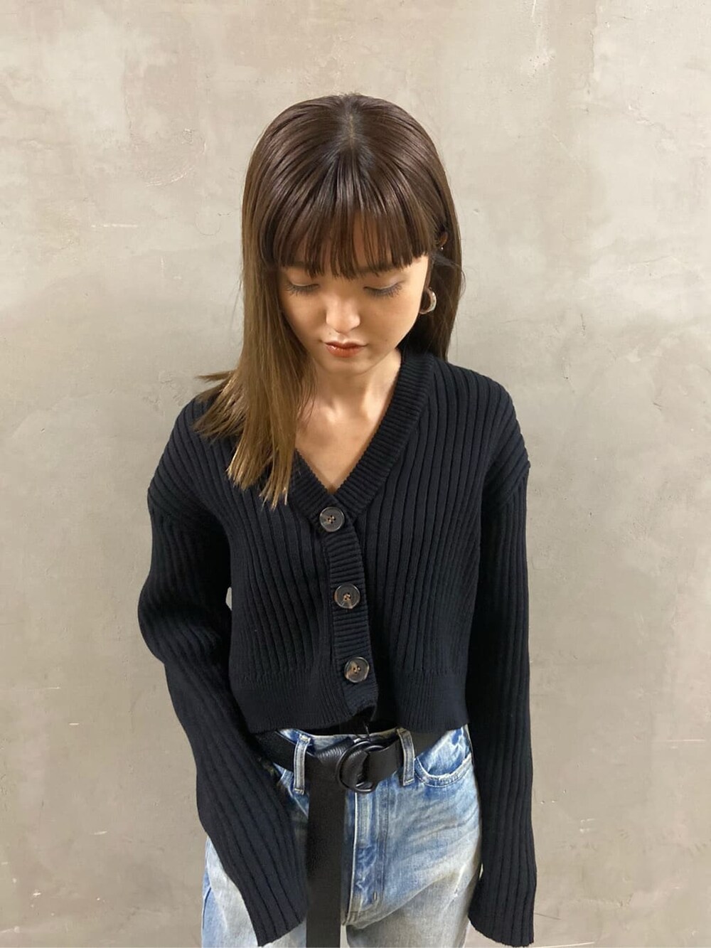 ブルー系のデニムパンツ、ブラック系のローファー、ブラック系のニット/セーターを着用したレディースの春コーディネートの4枚目の写真