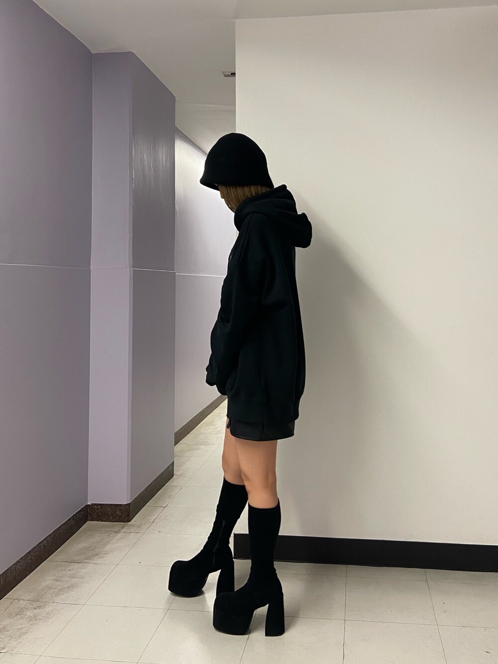 ブラック系のパーカー、その他のスカート、ブラック系のブーツを着用したレディースの秋コーディネートの3枚目の写真