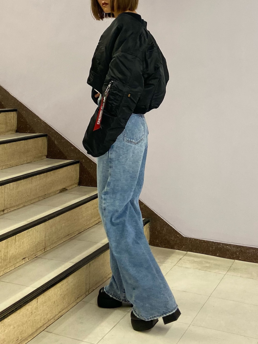 ブルー系のデニムパンツ、ブラック系のブーツ、ホワイト系のスウェットを着用したレディースの秋コーディネートの3枚目の写真