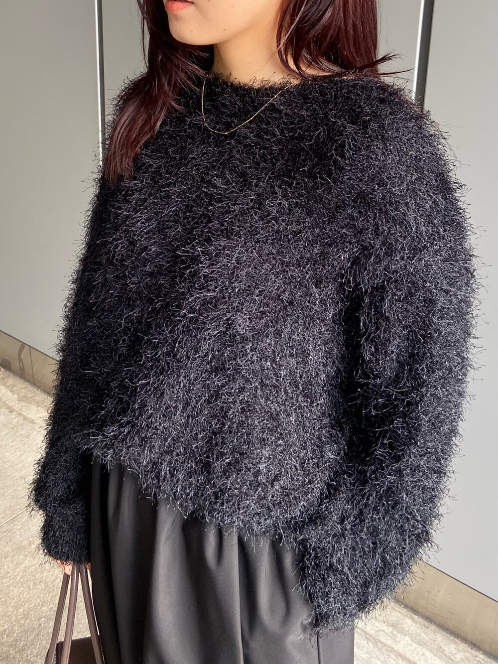 ブラック系のスカート、ブラウン系のボストンバッグ、ブラック系のブーツを着用したレディースの冬コーディネートの8枚目の写真