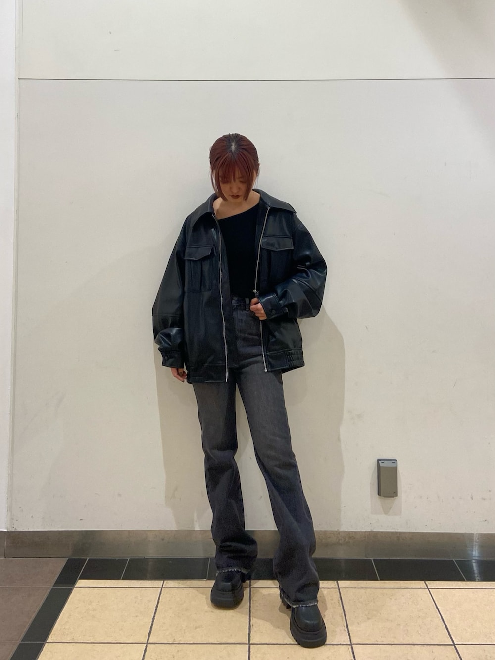 ブラック系のブルゾン、ブラック系のニット/セーター、ブラック系のブーツを着用したレディースの冬コーディネートの2枚目の写真