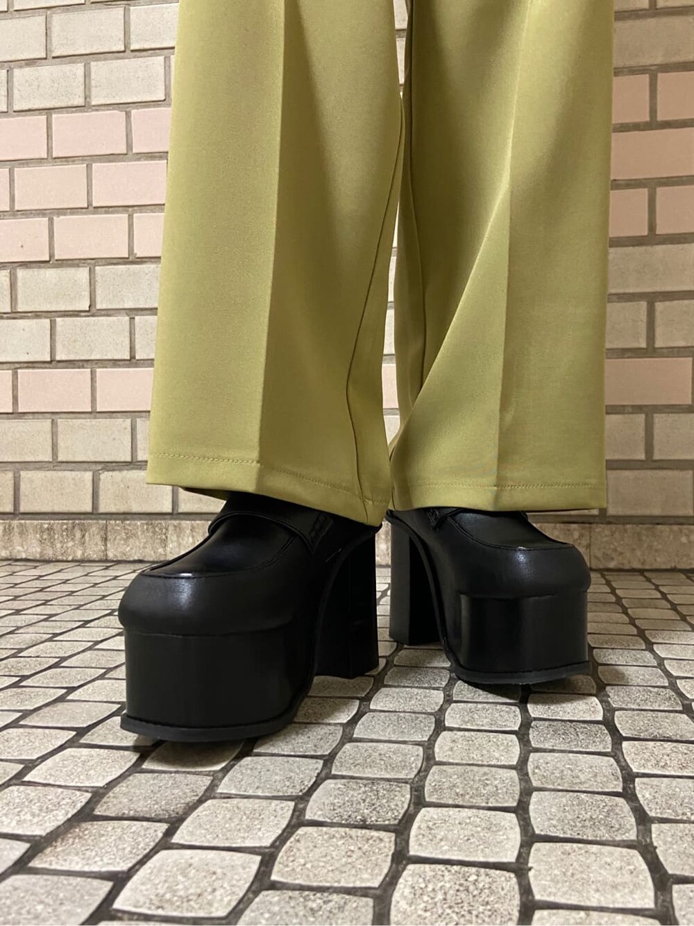 イエロー系のその他パンツ、ブラック系のローファー、ブラック系のニット/セーターを着用したレディースの秋コーディネートの5枚目の写真