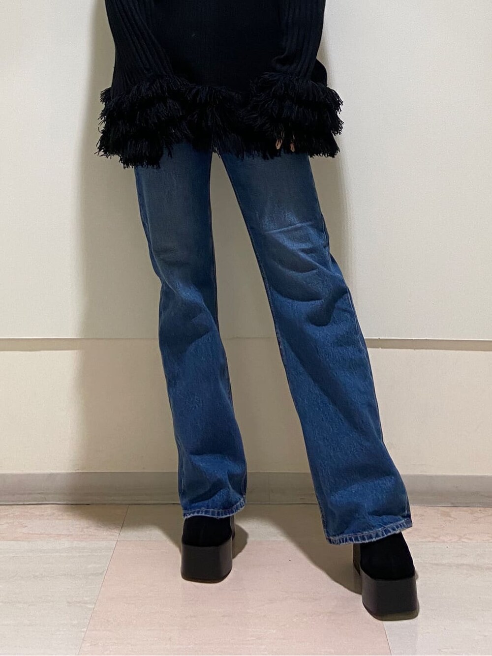 ブラック系のブーツ、ブルー系のデニムパンツ、ブラック系のニット/セーターを着用したレディースの冬コーディネートの4枚目の写真