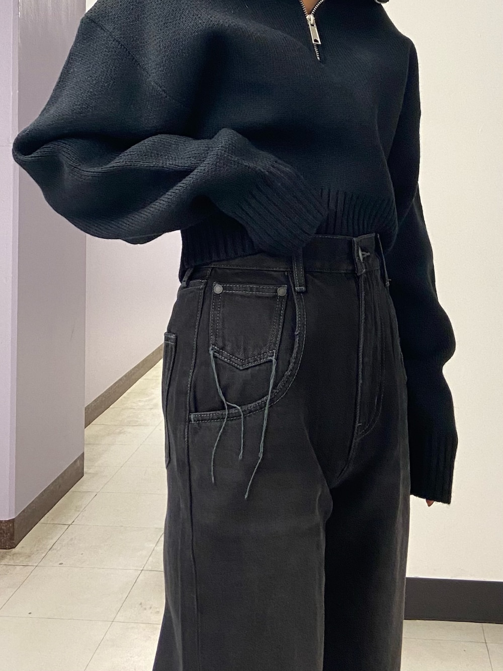 ブラック系のデニムパンツ、ブラック系のブーツ、ブラック系のニット/セーターを着用したレディースの秋コーディネートの6枚目の写真