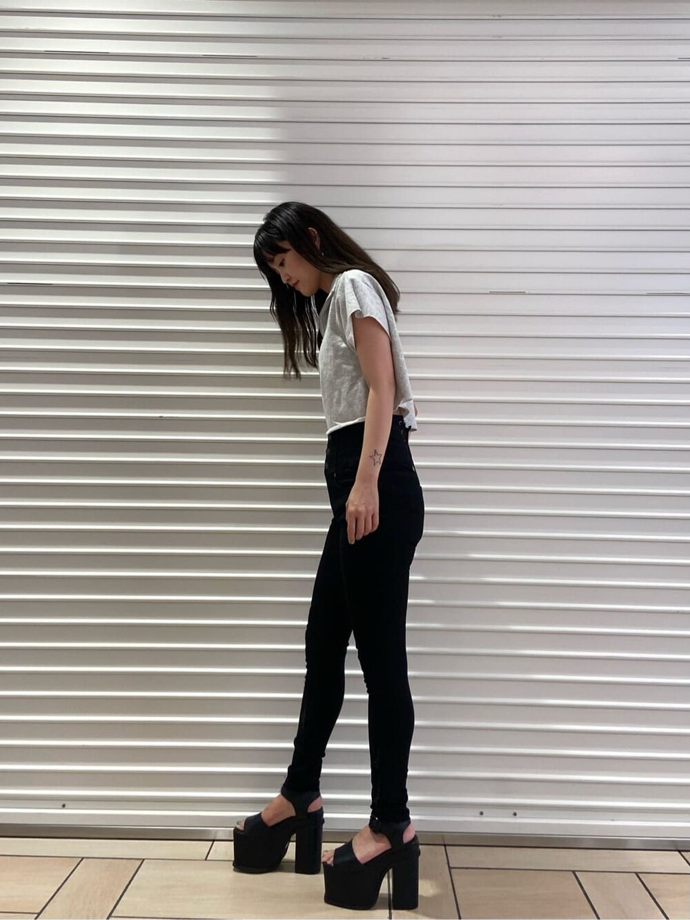 ブラック系のサンダル、ブラック系のデニムパンツ、グレー系のTシャツ/カットソーを着用したレディースの夏コーディネートの3枚目の写真