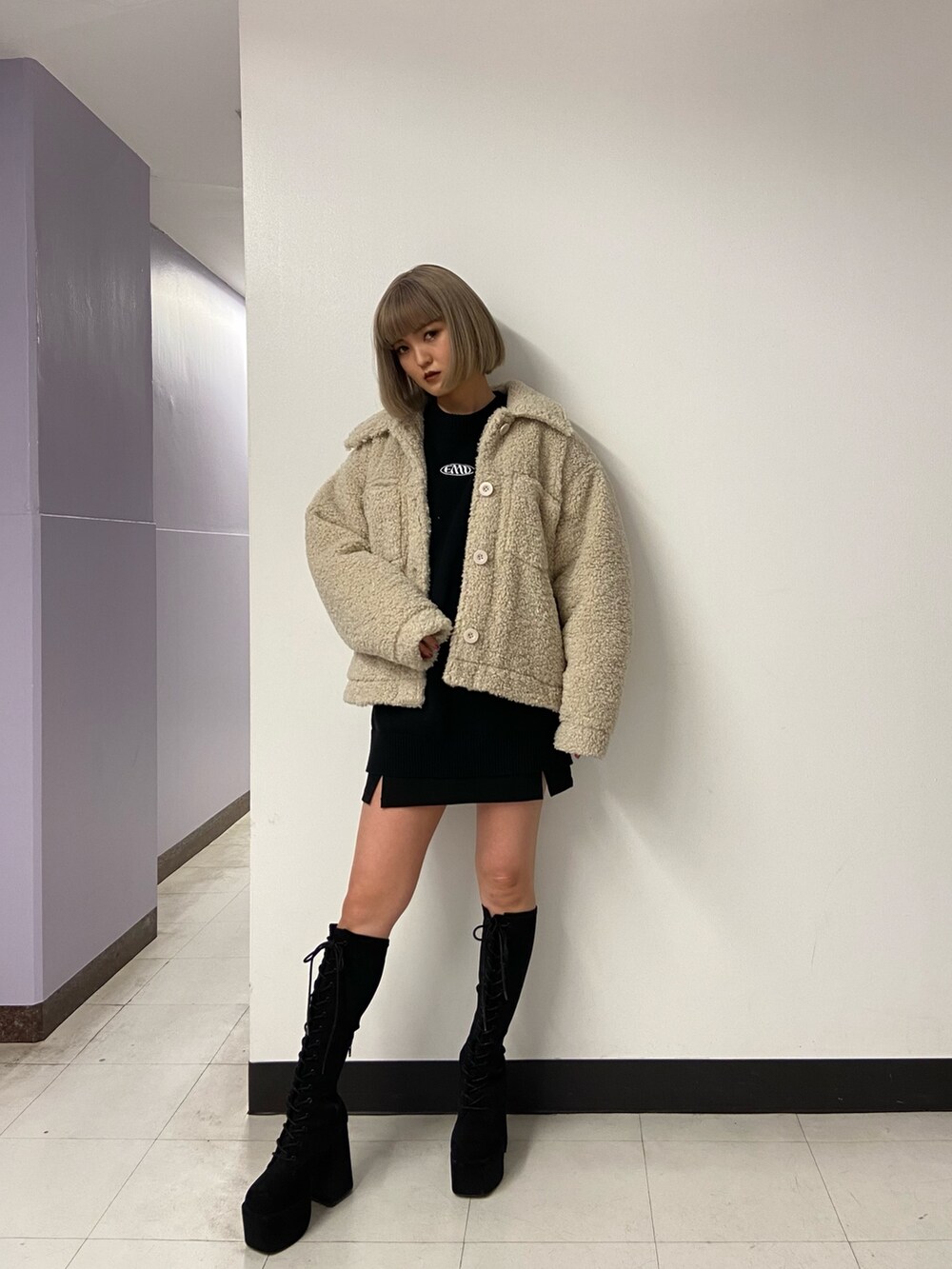 ブラック系のニット/セーター、ホワイト系のブルゾン、ブラック系のスカートを着用したレディースの冬コーディネートの2枚目の写真