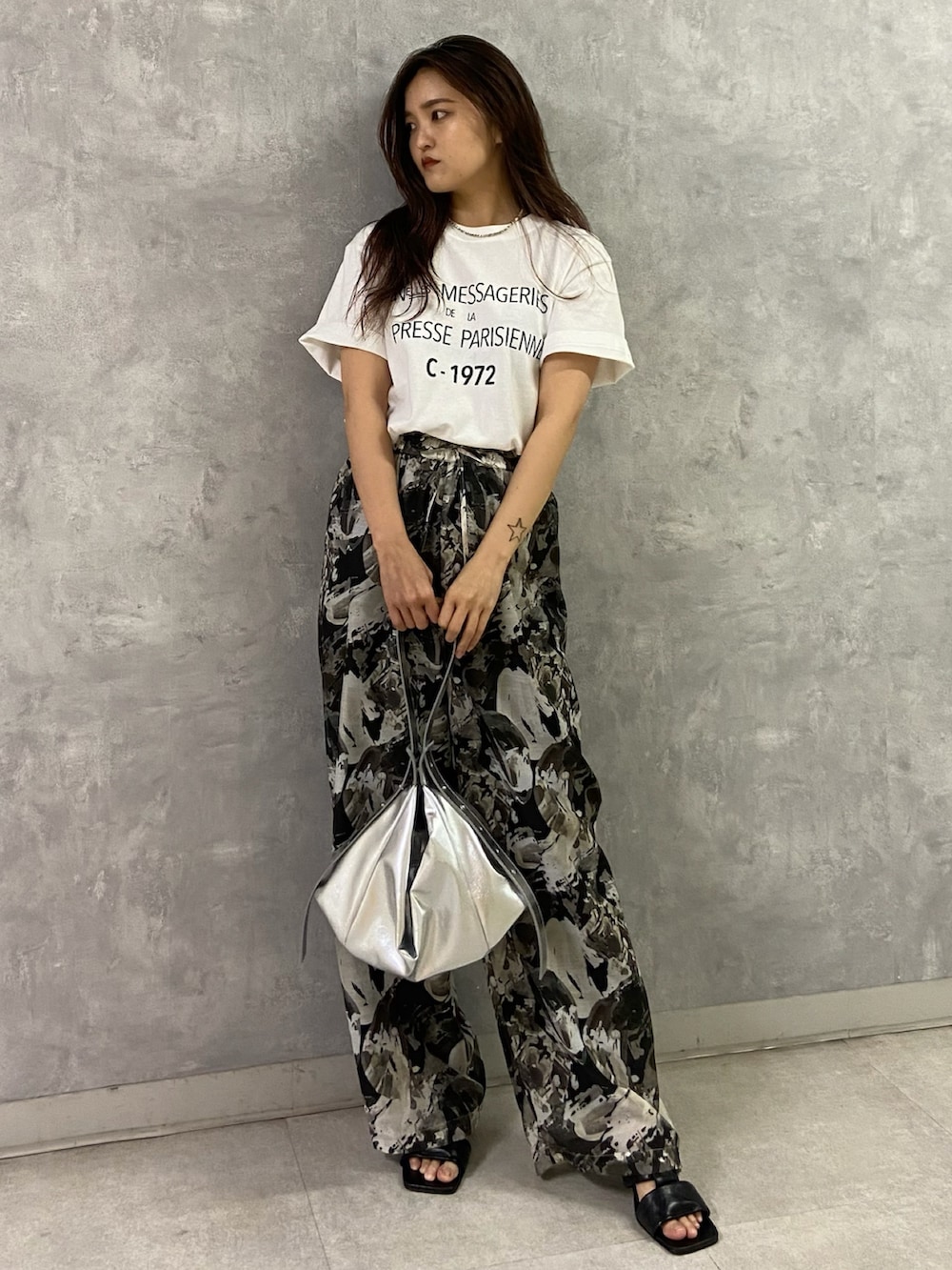 ホワイト系のTシャツ/カットソー、ブラック系のその他パンツ、シルバー系のショルダーバッグを着用したレディースの春コーディネートの2枚目の写真