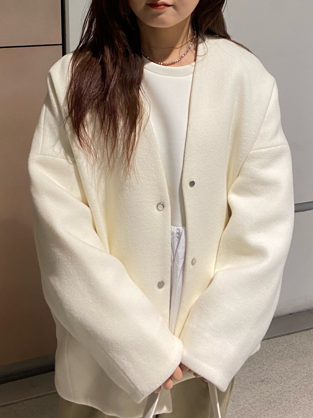 ホワイト系のノーカラージャケット、ホワイト系のTシャツ/カットソー、ベージュ系のその他パンツを着用したレディースの冬コーディネートの4枚目の写真