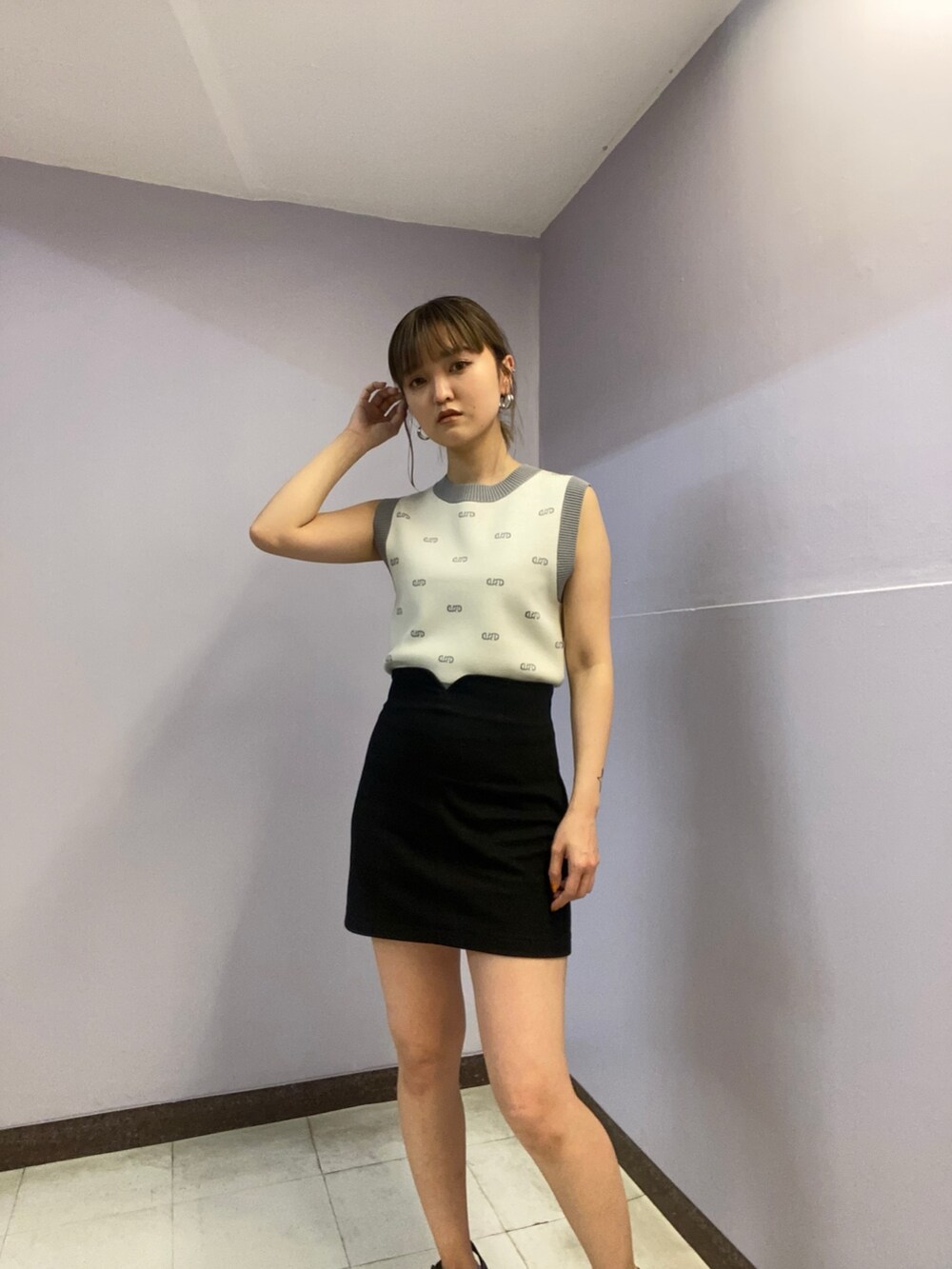 ホワイト系のニット/セーター、ブラック系のスカート、ブラック系のサンダルを着用したレディースの春コーディネートの4枚目の写真