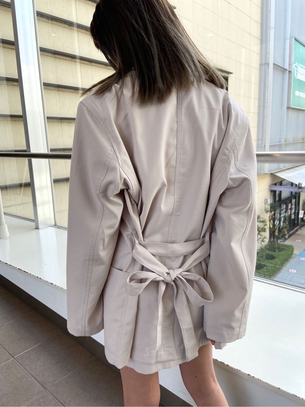 ホワイト系のテーラードジャケット、ブラック系のブーツ、ホワイト系のスカートを着用したレディースの春コーディネートの6枚目の写真