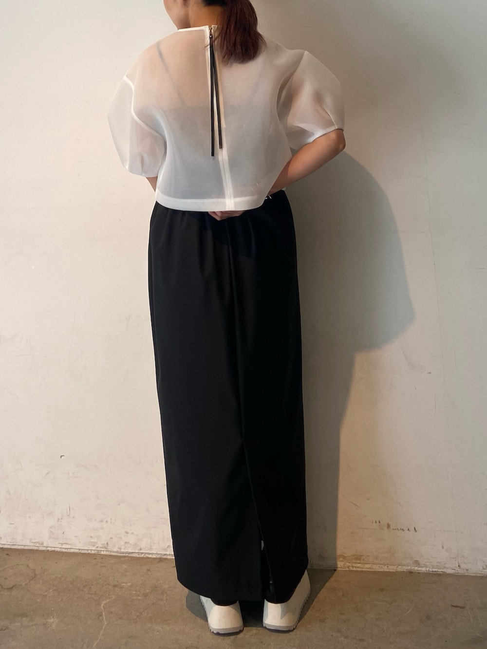 ホワイト系のシャツ/ブラウス、ブラック系のスカート、シルバー系のブレスレットを着用したレディースの春コーディネートの2枚目の写真