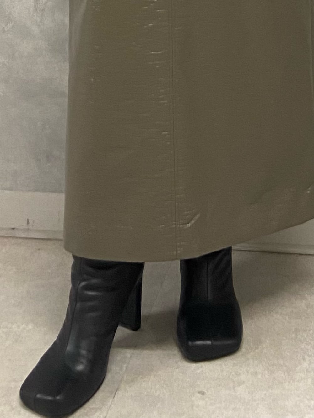 ブラック系のニット/セーター、グリーン系のスカート、ブラック系のブーツを着用したレディースの秋コーディネートの6枚目の写真