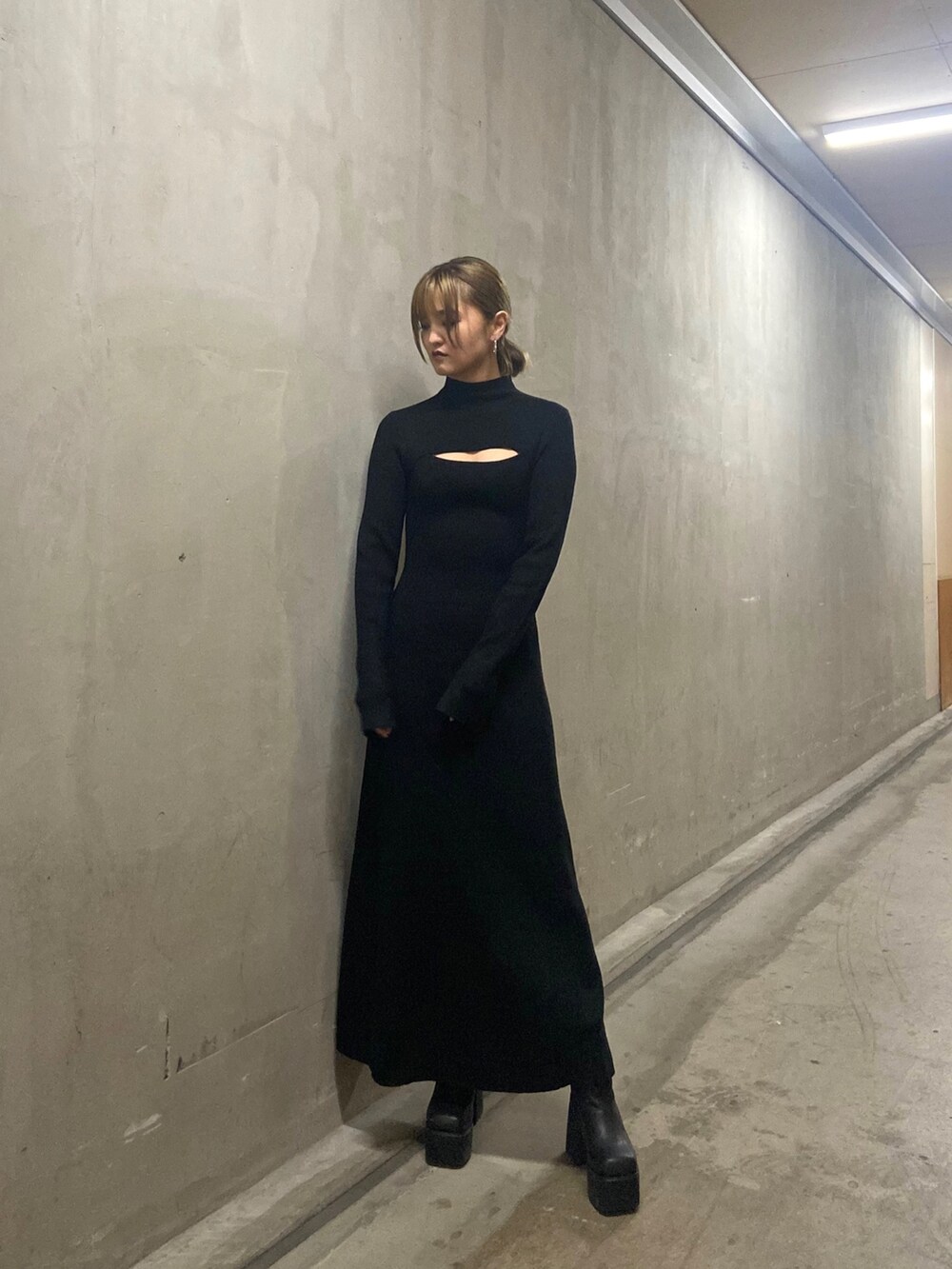 ブラック系のワンピース、ブラック系のブーツを着用したレディースの冬コーディネートの2枚目の写真