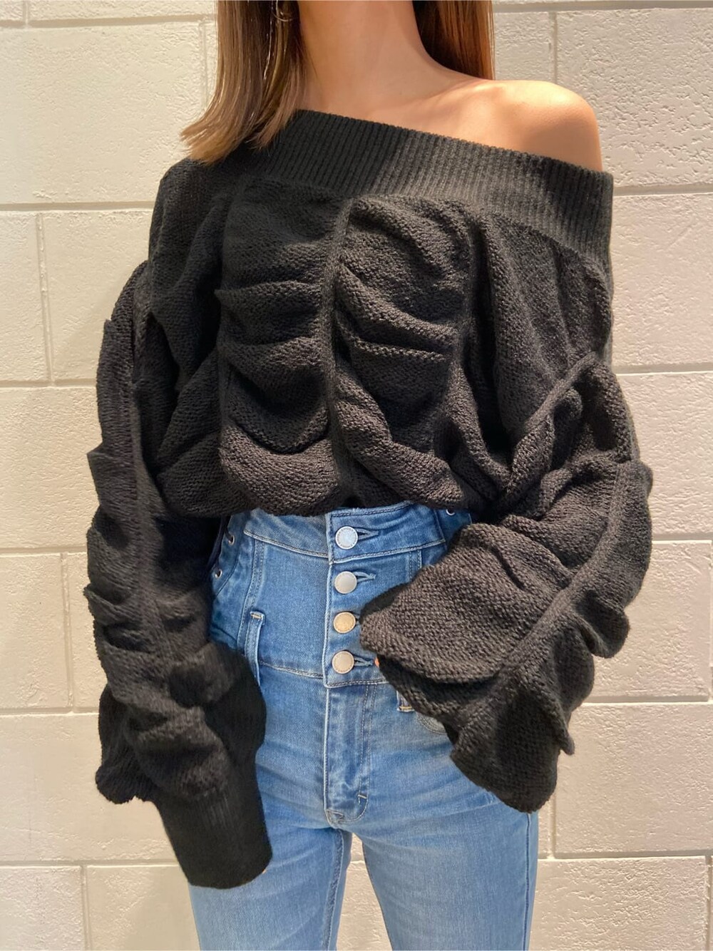 ブルー系のデニムパンツ、ブラック系のブーツ、ブラック系のニット/セーターを着用したレディースの冬コーディネートの3枚目の写真