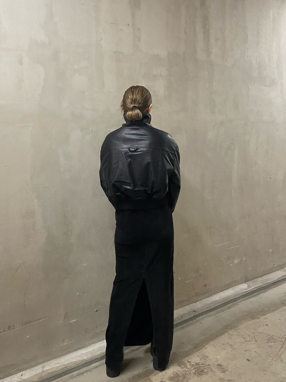 ブラック系のブルゾン、ブラック系のスカート、ブラック系のブーツを着用したレディースの秋コーディネートの4枚目の写真