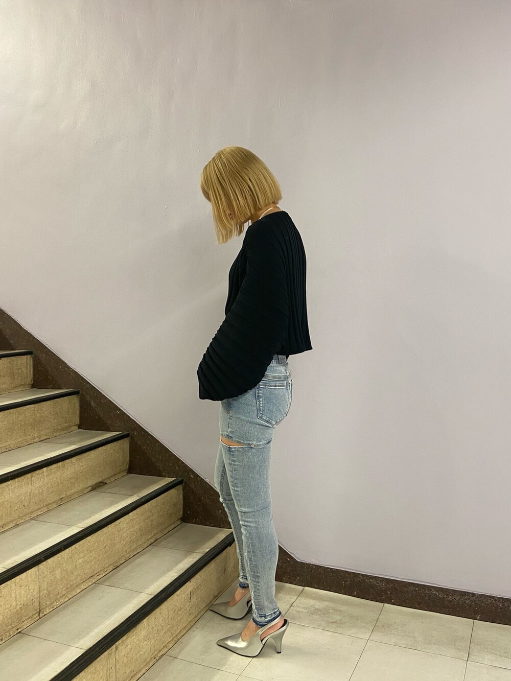 ブラック系のニット/セーター、ブルー系のデニムパンツ、シルバー系のパンプスを着用したレディースの冬コーディネートの3枚目の写真