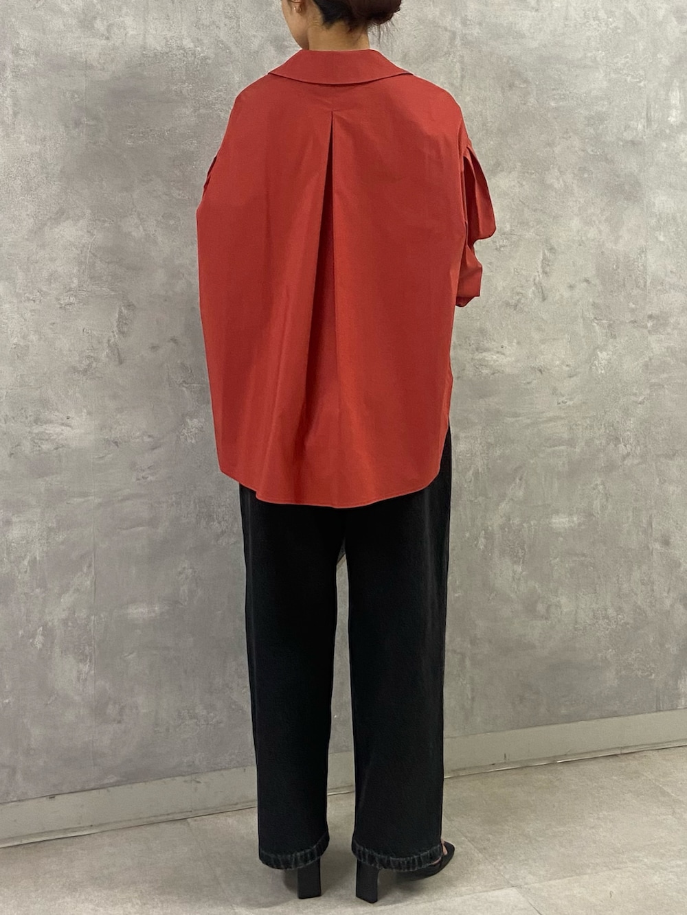 オレンジ系のシャツ/ブラウス、ブラック系のサンダル、ブラック系のデニムパンツを着用したレディースの夏コーディネートの4枚目の写真