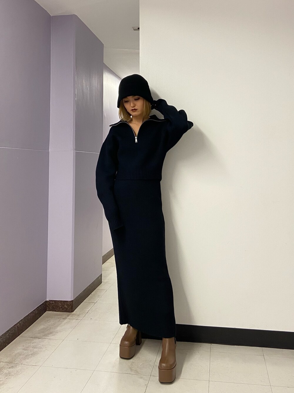 ブラック系のニット/セーター、ブラウン系のブーツ、ブラック系のスカートを着用したレディースの冬コーディネートの2枚目の写真