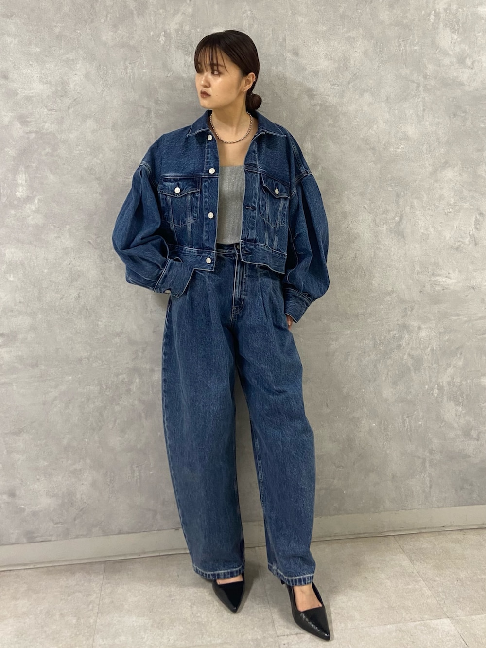 ブルー系のデニムジャケット、シルバー系のキャミソール、ブルー系のデニムパンツを着用したレディースの春コーディネートの2枚目の写真