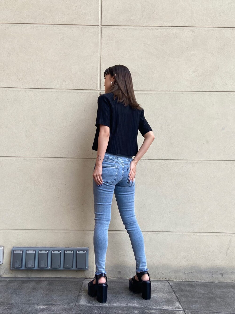 ブルー系のデニムパンツ、ホワイト系のタンクトップ、ブラック系のサンダルを着用したレディースの春コーディネートの2枚目の写真